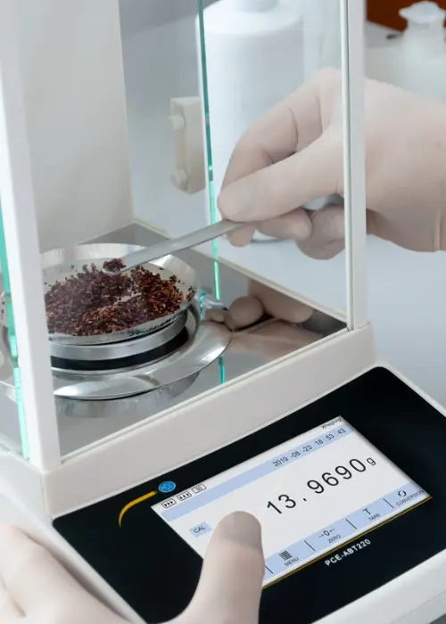 Balanza de laboratorio PCE-ABT 220, mostrando la medición precisa de muestras en un entorno controlado. La balanza digital ofrece una resolución alta y una pantalla clara para un pesaje exacto de sustancias como especias o ingredientes farmacéuticos.